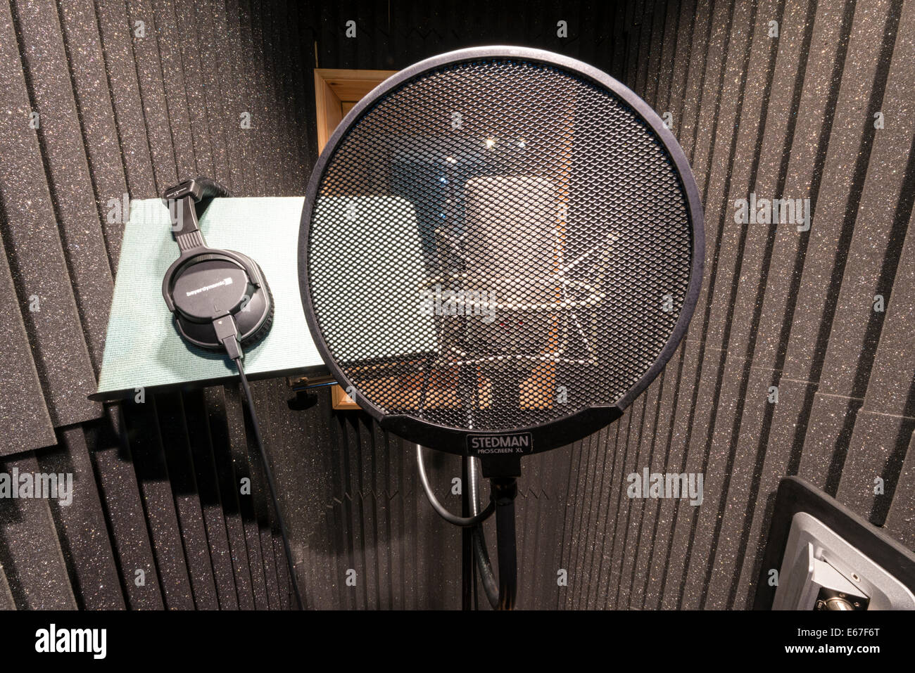 A neuman microphone in a vocal booth in a music recording studio with a pop shield in front Stock Photo