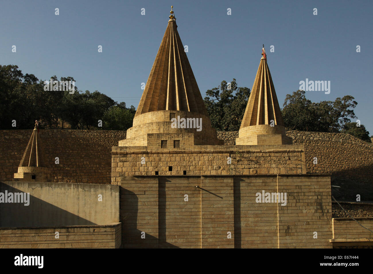 Conical roofs characteristic of Yazidi sites mark the tomb shrine of Sheikh Adi ibn Musafir founder of Yazidism in the village of Lalish situated in the Shekhan District of Nineveh Governorate in northern Iraq. The Yazidis or Yezidis are a Kurdish ethno religious group. Their religion, Yazidism is linked to ancient Mesopotamian religions and combines aspects of Zoroastrianism, Hinduism, Islam, Christianity and Judaism. Stock Photo