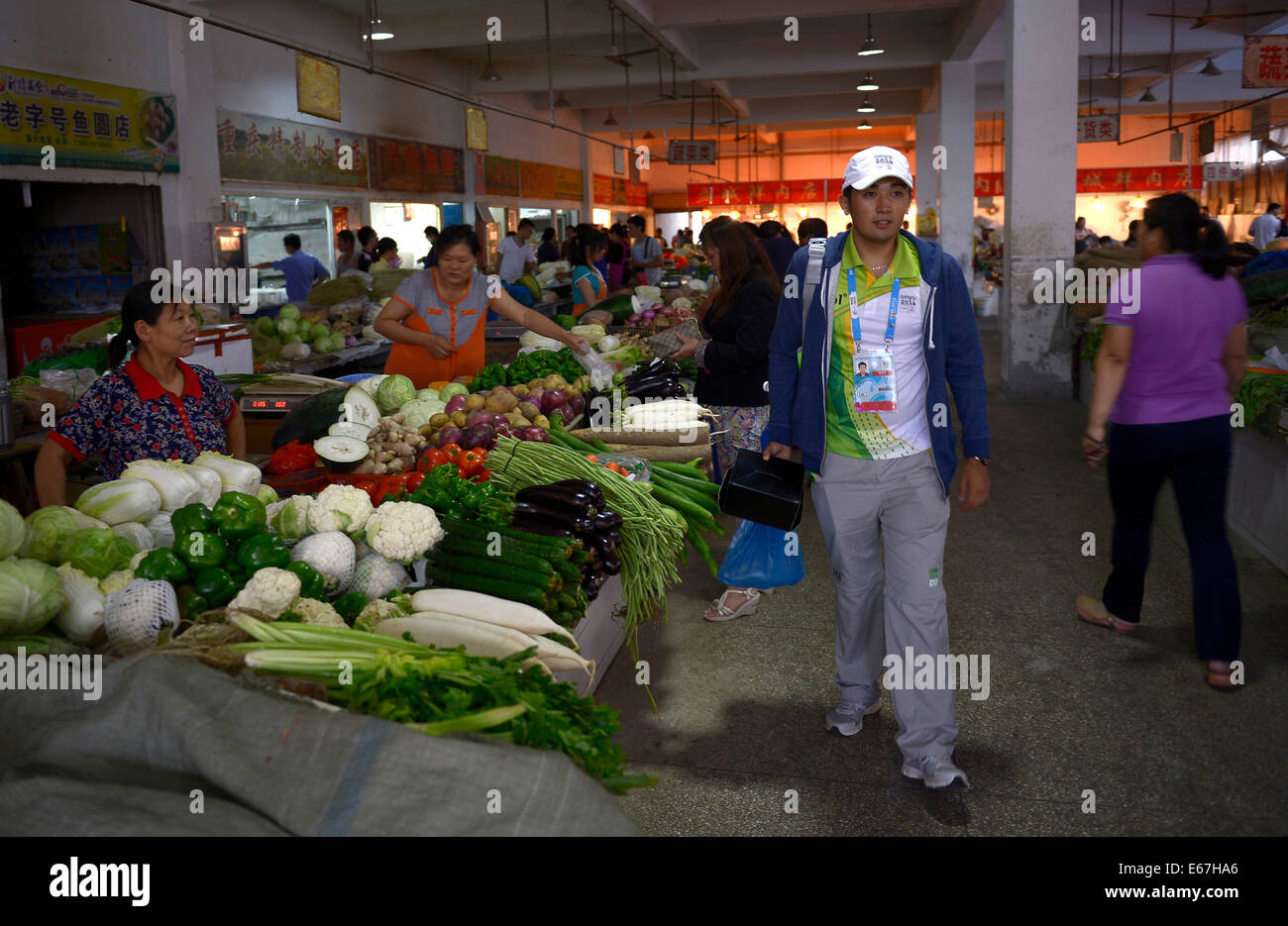 (140817) -- NANJING, Aug. 17, 2014 (Xinhua) -- Medeu Askhatuly walks in a market to buy food for his dinner during Nanjing 2014 Youth Olympic Games on Aug. 17, 2014.       21-year-old Medeu Askhatuly from Kazahkstan works as a volunteer of language service for cycling event during the Nanjing 2014 Youth Olympic Games. He is a senior student majoring in International Economics and Trade in Nanjing University of Information Science and Technology and is fluent in Kazakh, Russian, English and Chinese. He came to China with his father when he was a child and became fascinated by Chinese culture. A Stock Photo