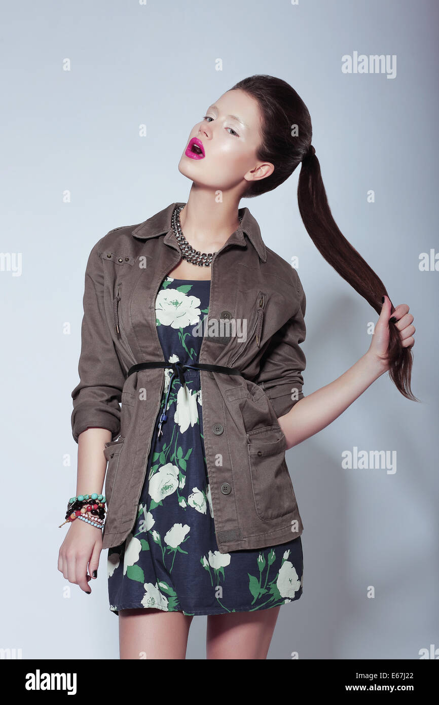 Trendy Fashion Model in Elegant Clothes holding her Tress Stock Photo