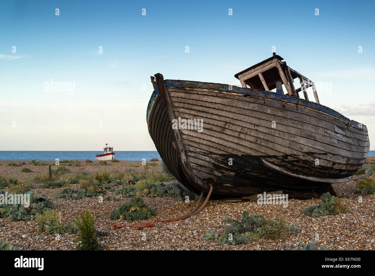Abandoned fishing boat on shingle beach landscape at sunset Stock Photo ...