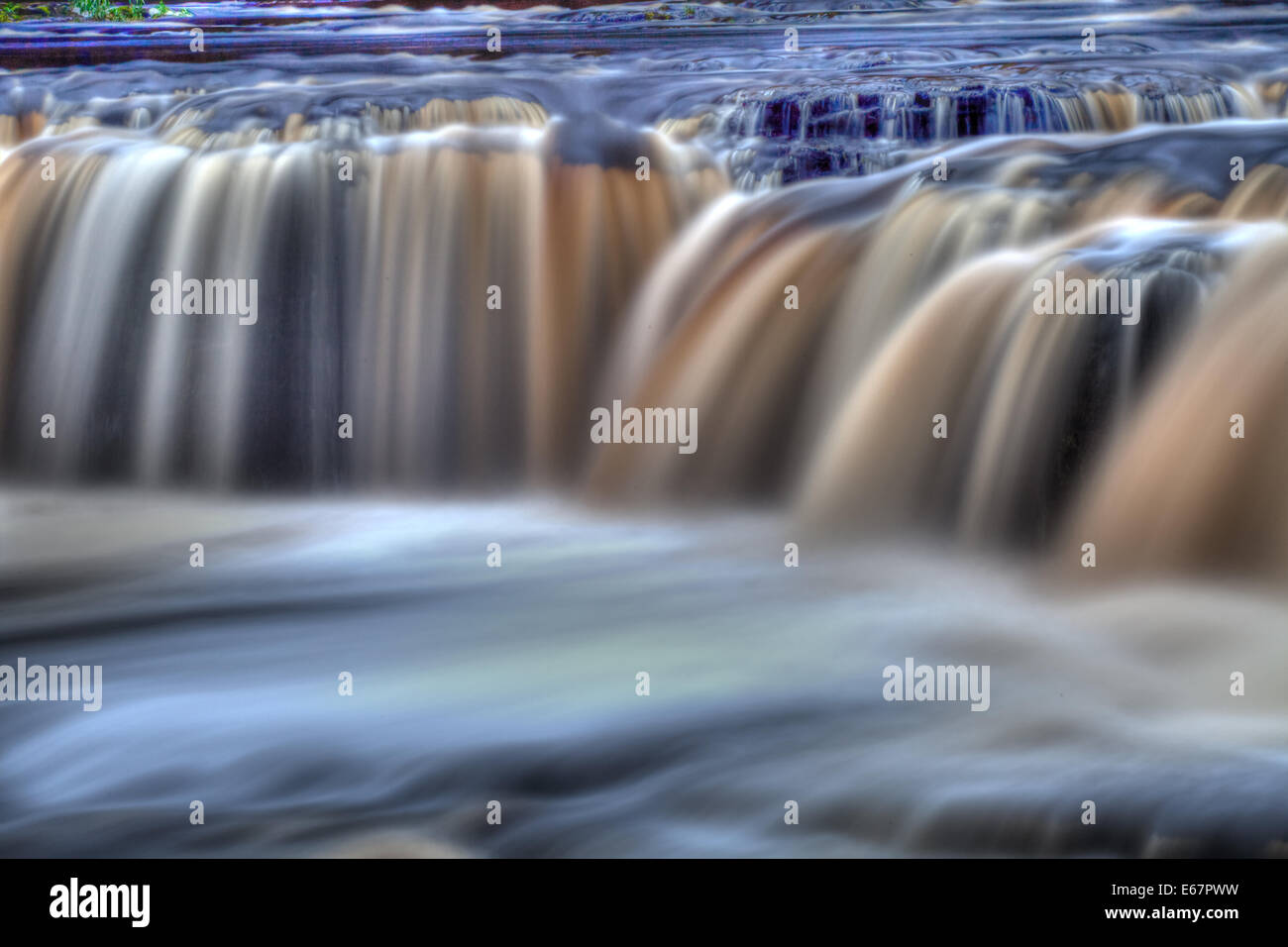 The many colours of the fast flowing Aysgarth Falls. Stock Photo