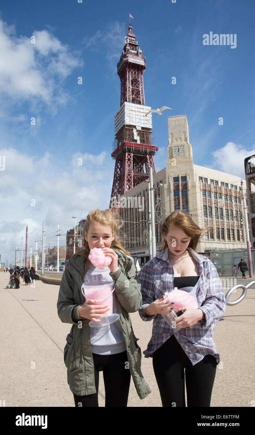 Teenagers eating candy floss in Blackpool Lancashire UK In background the famous Blackpool Tower Stock Photo