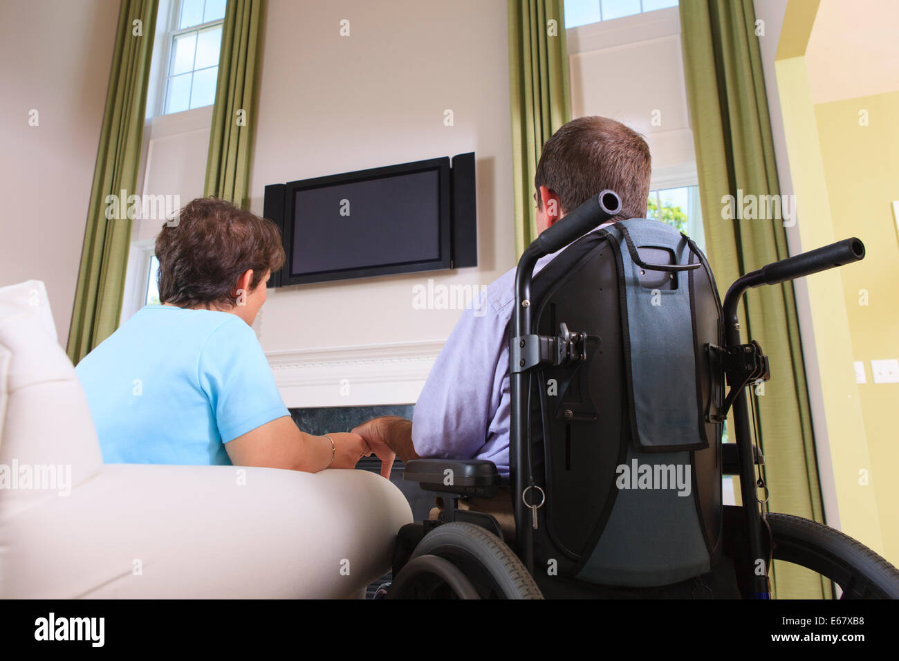 Couple with Cerebral Palsy watching TV in their home Stock Photo
