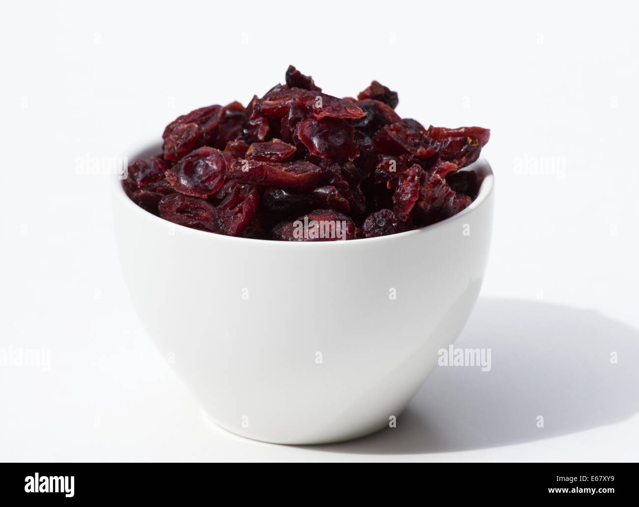 Dried cranberries in a white bowl on white background Stock Photo