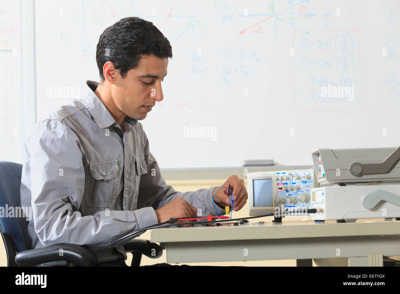 Engineering student inserting component into prototyping breadboard for ...
