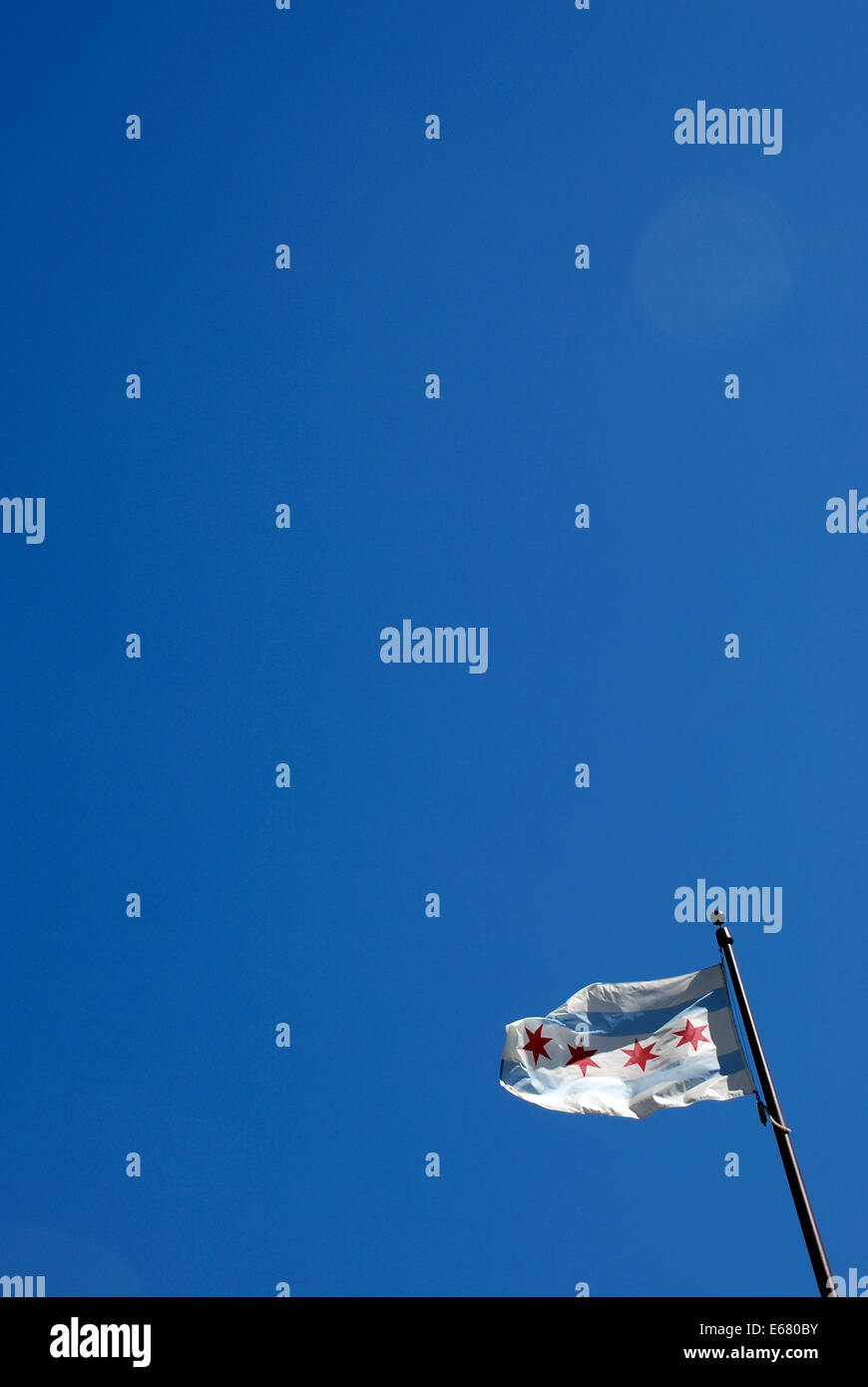 The municipal flag of Chicago on Michigan Avenue Bridge blowing in the wind on a flag pole in Chicago against clear blue sky. Stock Photo