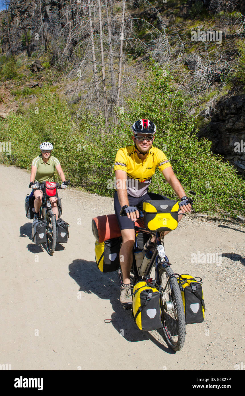 Couple mountain biking cycling riding old wooden railway trestles trail