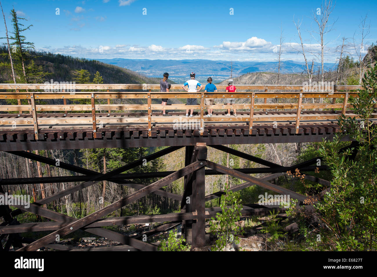 Mountain biking cycling riding the old wooden railway trestles trail in the Myra Canyon, Kelowna, British Columbia, Canada. Stock Photo