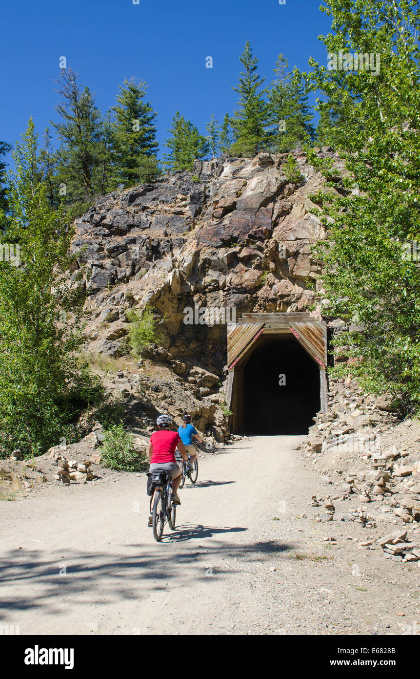 Mountain biking cycling riding the wooden railway trestles trail tunnel in the Myra Canyon, Kelowna, British Columbia, Canada. Stock Photo