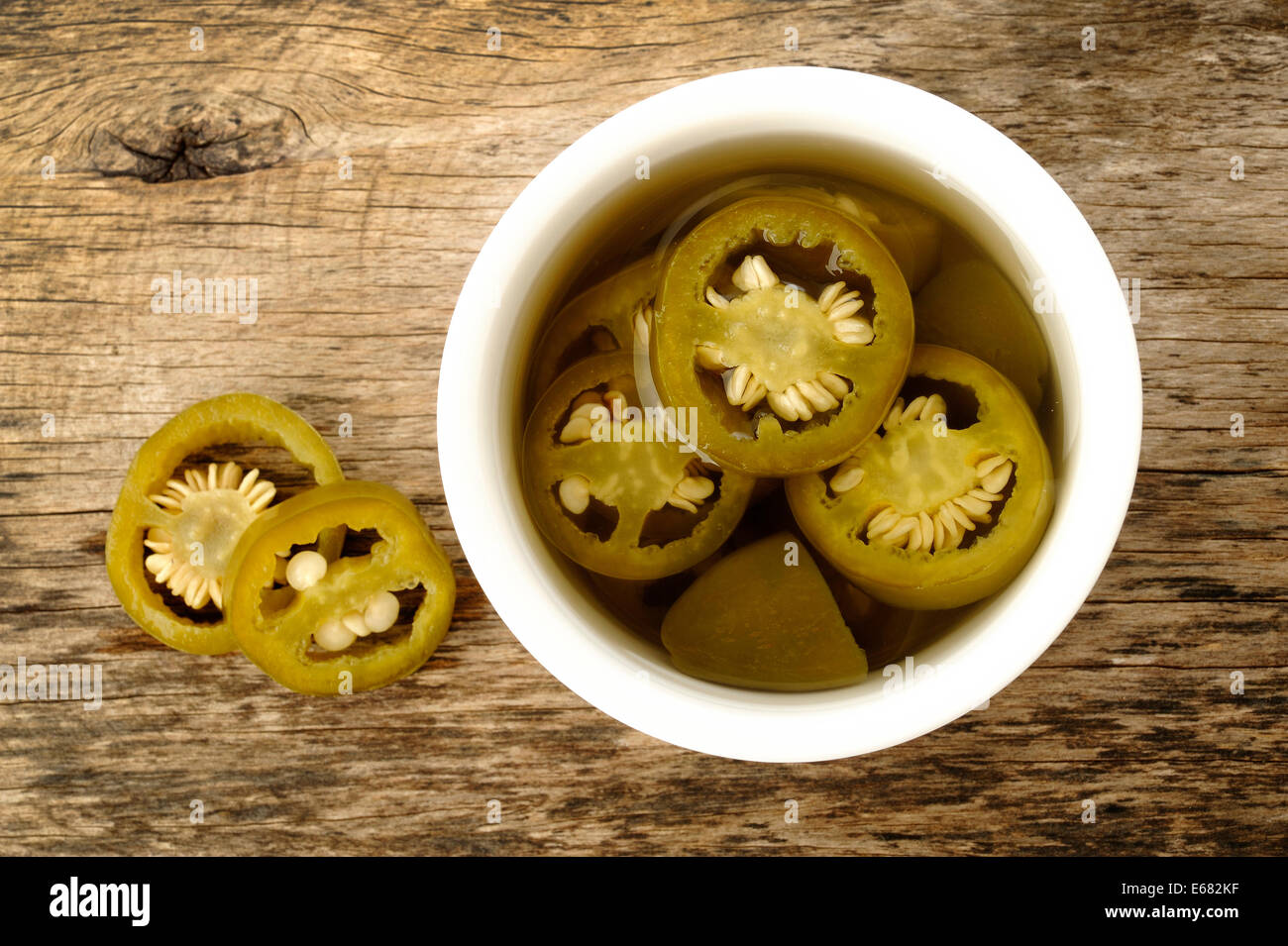 pickled sliced green jalapeno peppers in white bowl Stock Photo