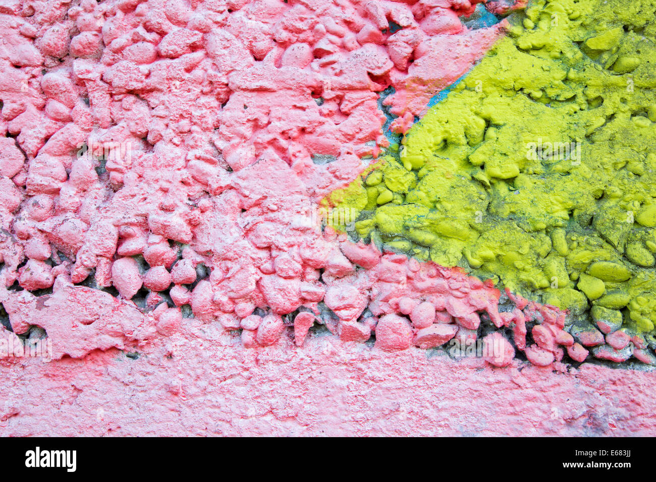 pink and yellow coat on the concrete wall - detail Stock Photo