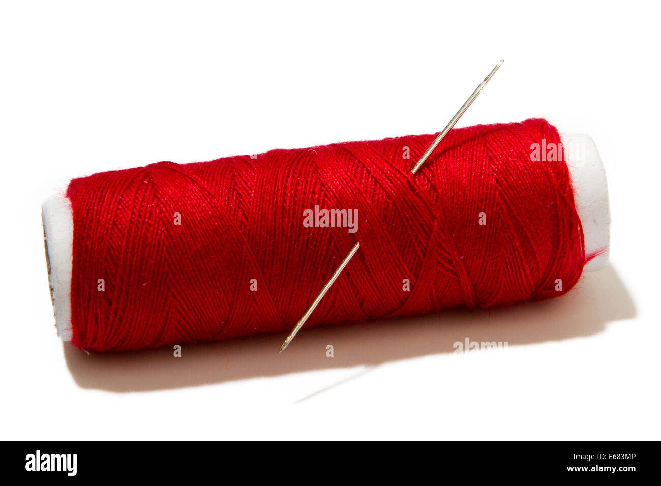 skein of red thread with a needle for sewing isolated on white
