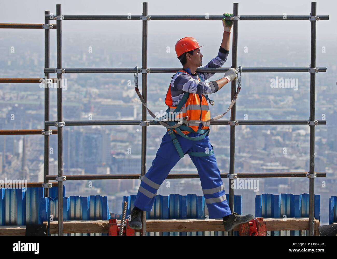 Moscow, Russia. 18th Aug, 2014. A construction worker carrying scaffolding at the Federation Tower skyscraper at the Moscow International Business Centre (MIBC), or Moscow City. Credit:  Mikhail Metzel/ITAR-TASS/Alamy Live News Stock Photo
