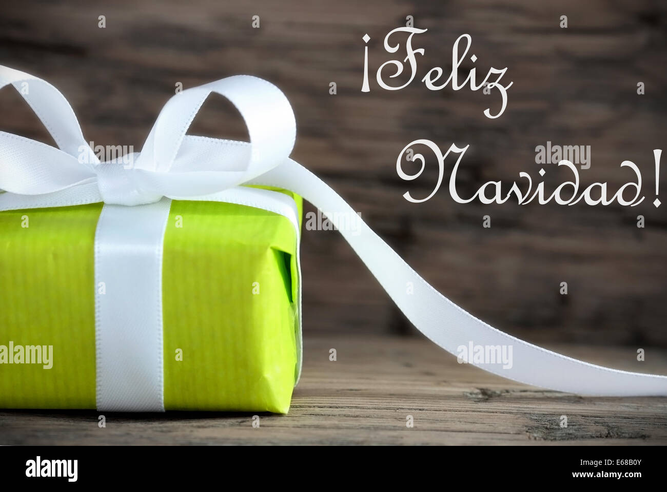 Green Present with the Spanish Words Feliz Navidad, which means Merry Christmas, on Wooden Background Stock Photo
