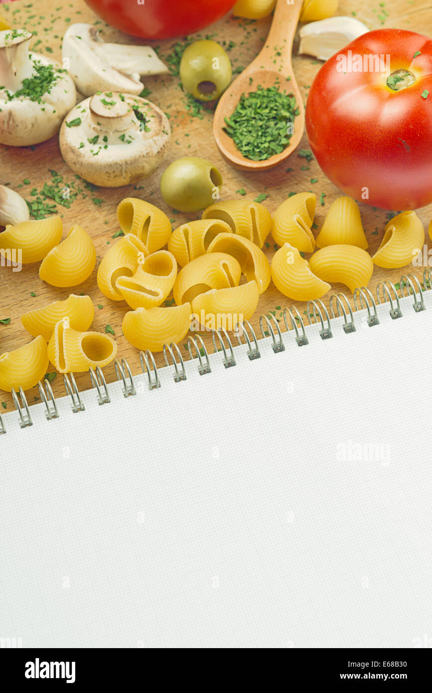 https://c8.alamy.com/comp/E68B30/garlic-parsley-mushroom-tomato-pasta-recipe-book-on-wooden-board-in-E68B30.jpg