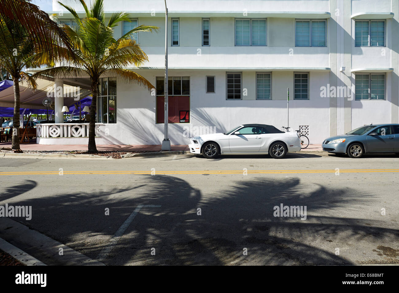 White Mustang car camouflaged by the white wash walls of an art deco building off Ocean Drive Stock Photo