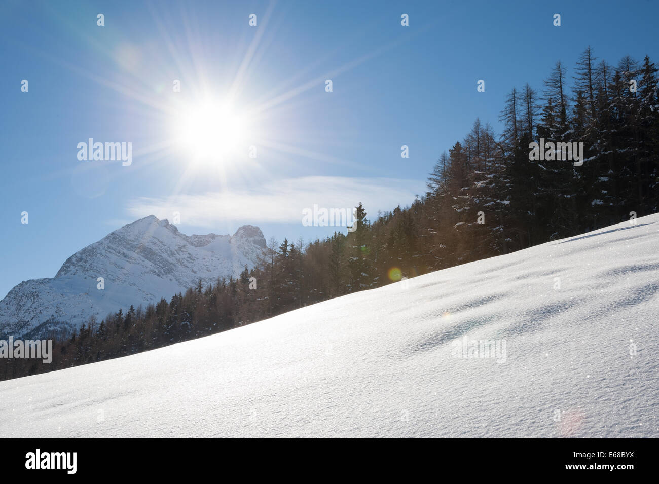 Sun low over the snow in the Swiss Alps near the village of Saas-Fee. Stock Photo