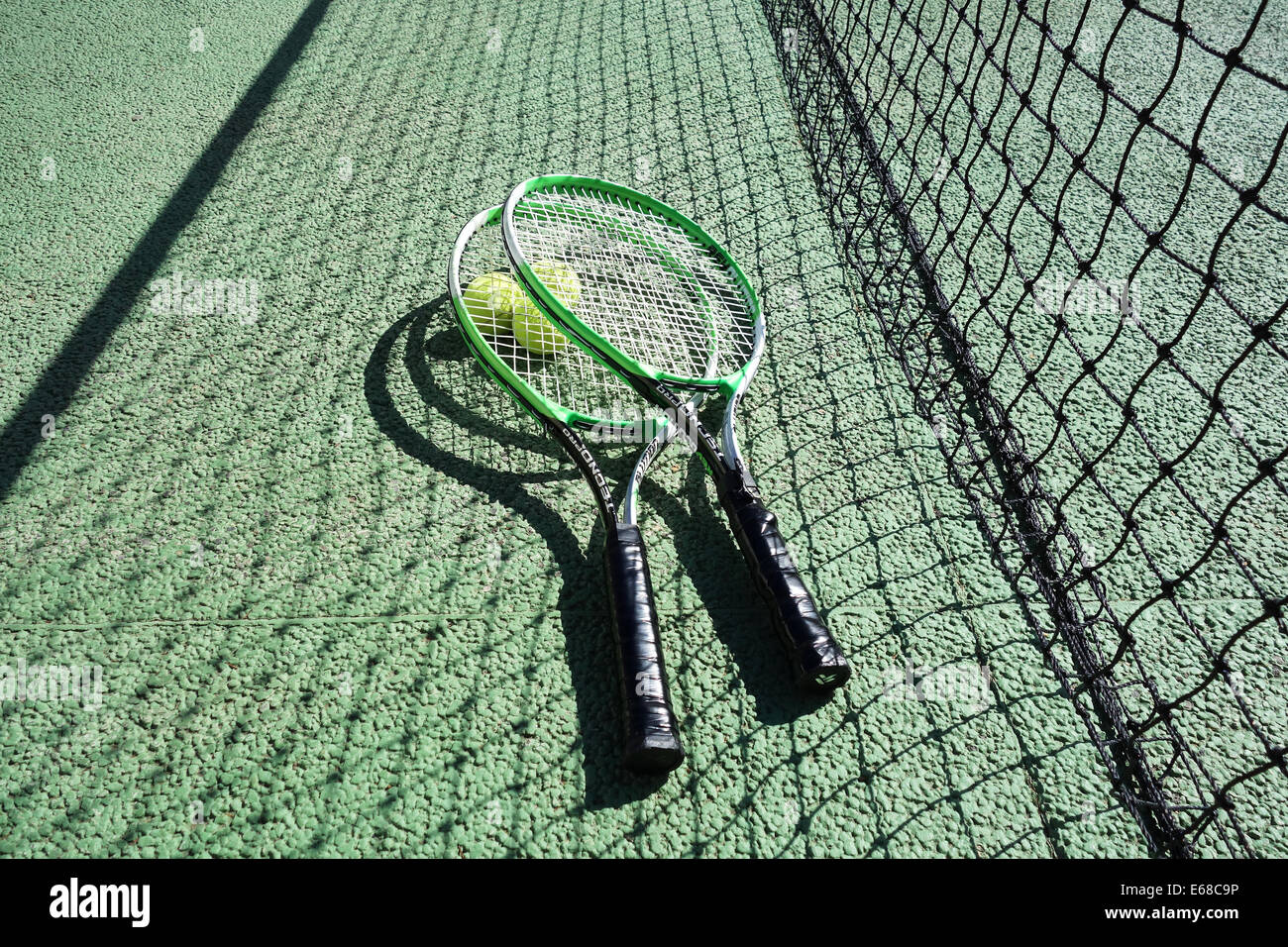 Tennis, tennis rackets and balls on a tennis court showing net. Tennis Stock Photo