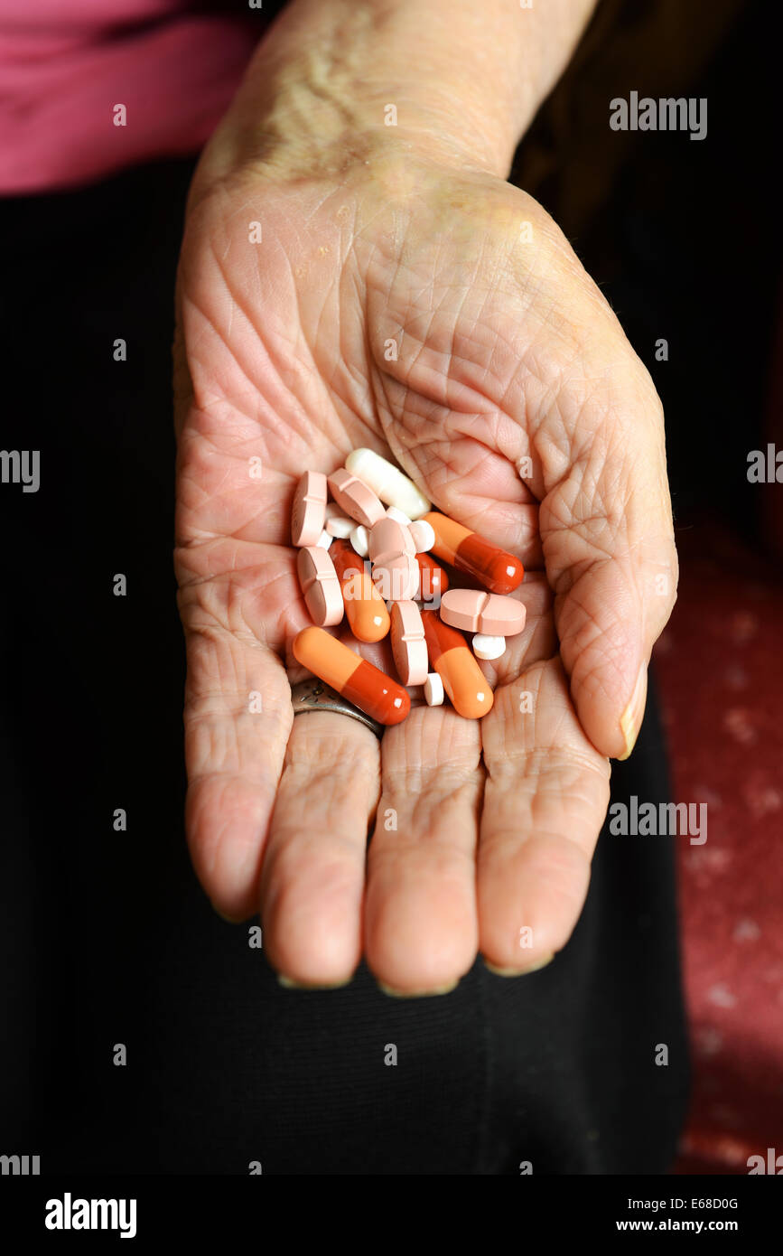 Elderly hands holding tablets, pills, medication. Old woman's hands showing capsules or pills Stock Photo