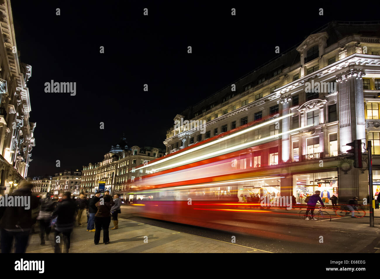 A London bus drives through the centre of London at night. A slow shutter speed blurs the bus as it moves by. London, UK. Ed Mar Stock Photo