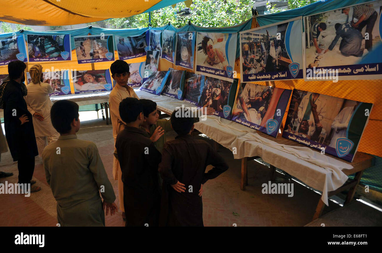 Peshawar, Pakistan. 18th Aug, 2014. People taking keen interest in watching posters of desolated people of Gaza by invasion of Israel, during a photo exhibition held by Jamat-e-Islami in Peshawar on Monday, August 18, 2014. Credit:  Asianet-Pakistan/Alamy Live News Stock Photo