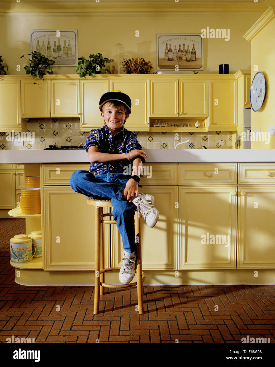 Young boy sitting in modern kitchen Stock Photo