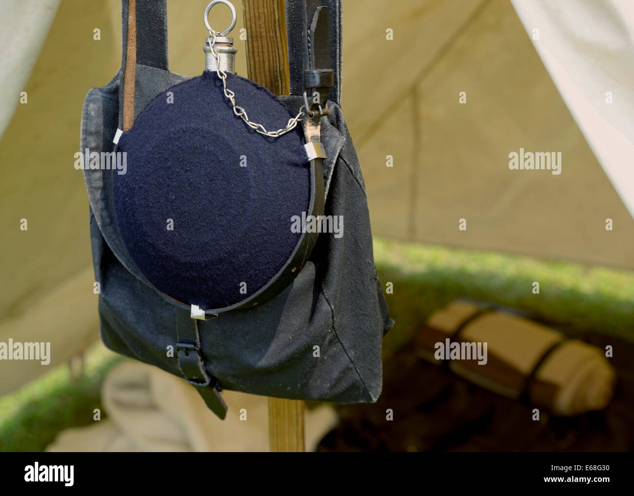 A blue Union Army canteen hangs in a Civil War re-enactor's encampment during a living history event. Stock Photo