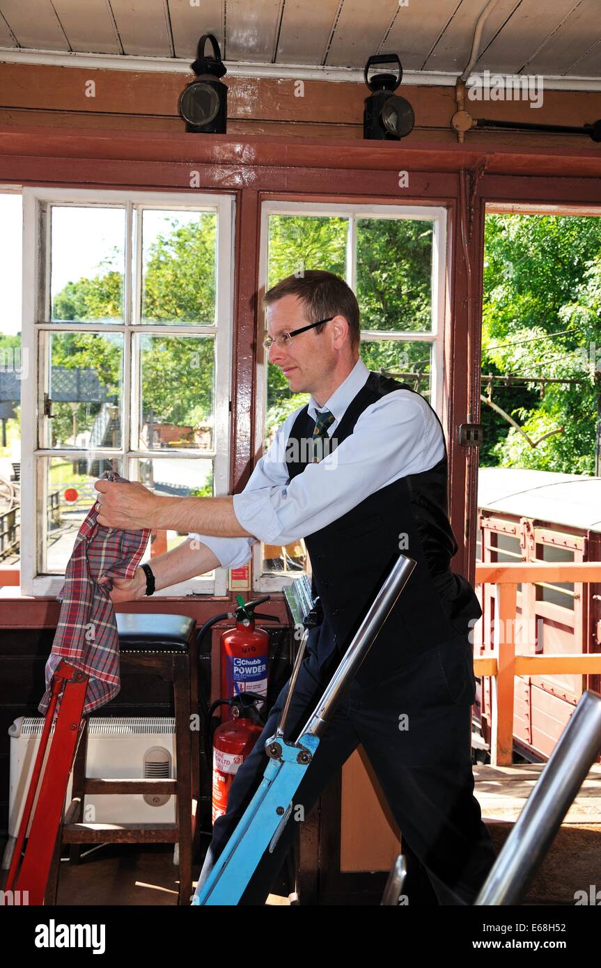 Signalman operating the Main Line lever on the mechanical lever frame inside the signal box at the railway station, Highley. Stock Photo