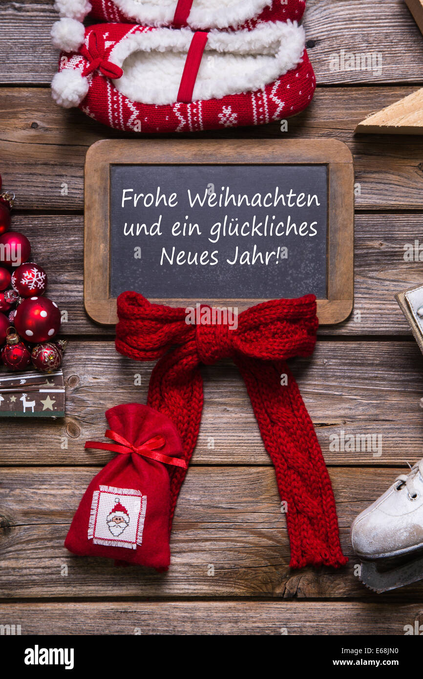 German merry christmas card with text - decorated in red, wood and white - country style. Stock Photo
