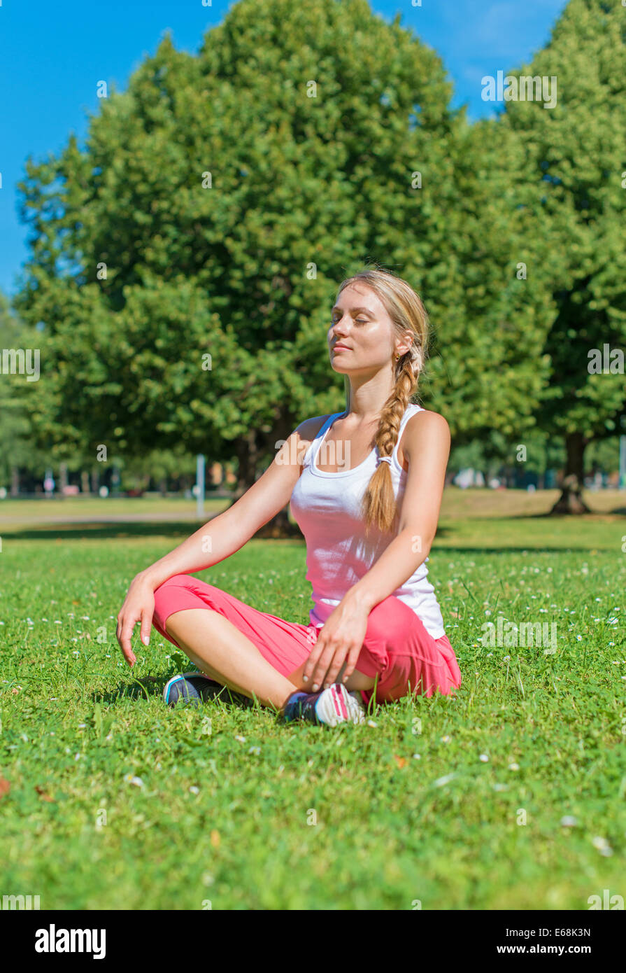 Young woman doing yoga in the park Stock Photo - Alamy