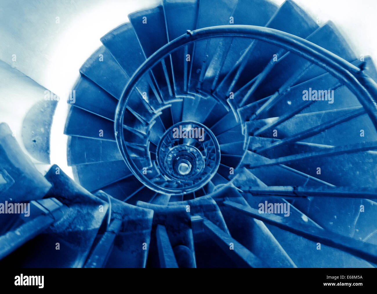 A spiral staircase bathed in blue light creates an interesting abstract image Stock Photo
