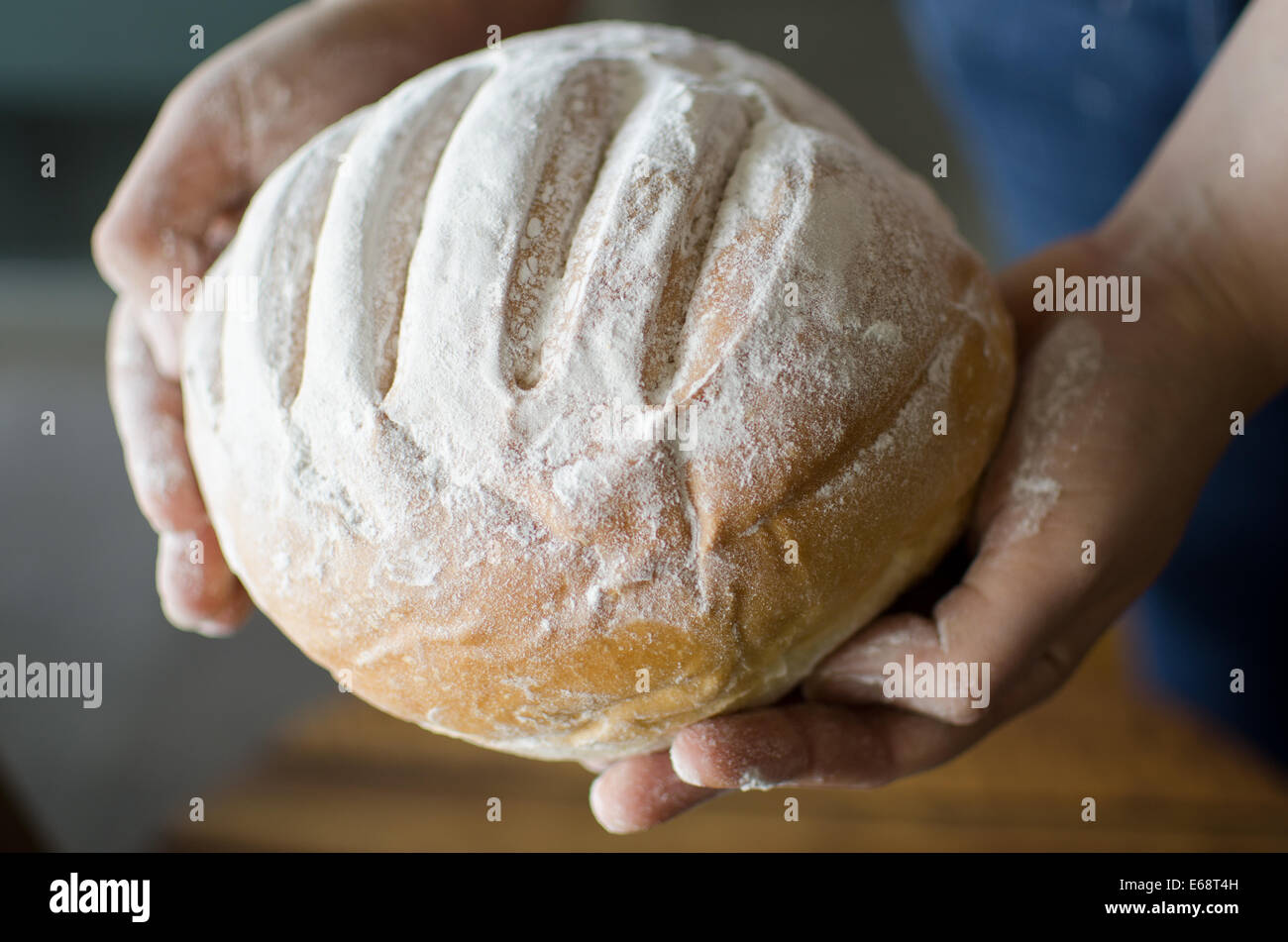 Hands holding homemade country bread Stock Photo - Alamy