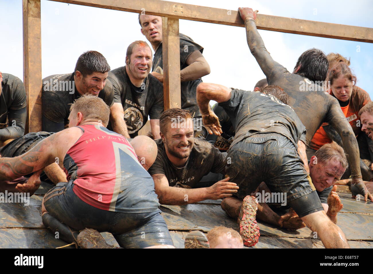 Tough Mudders climbing the Pyramid Scheme obstacle Stock Photo