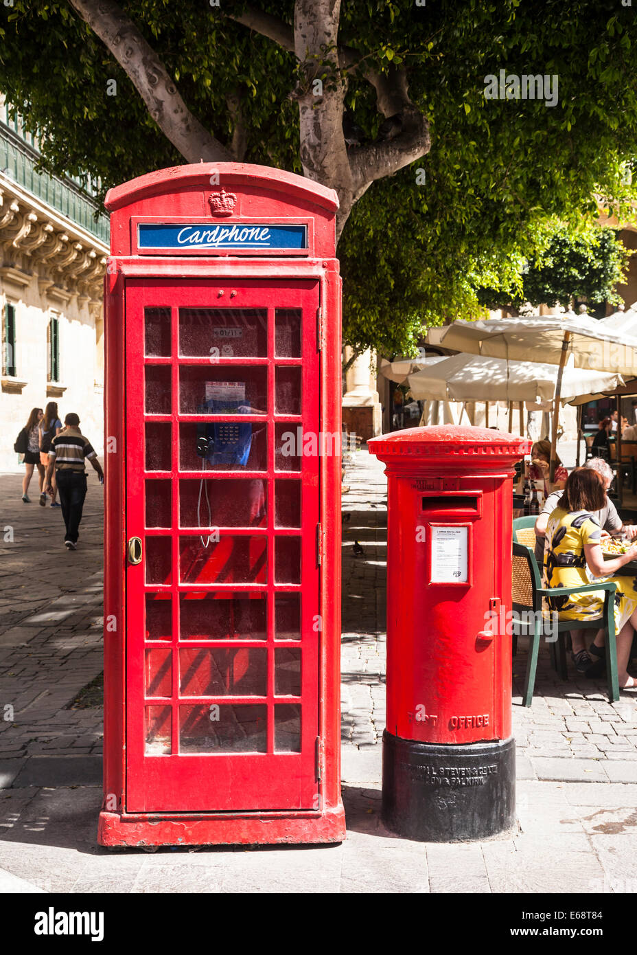 Old red British phone and post boxes together on a Valletta street, Malta. Stock Photo