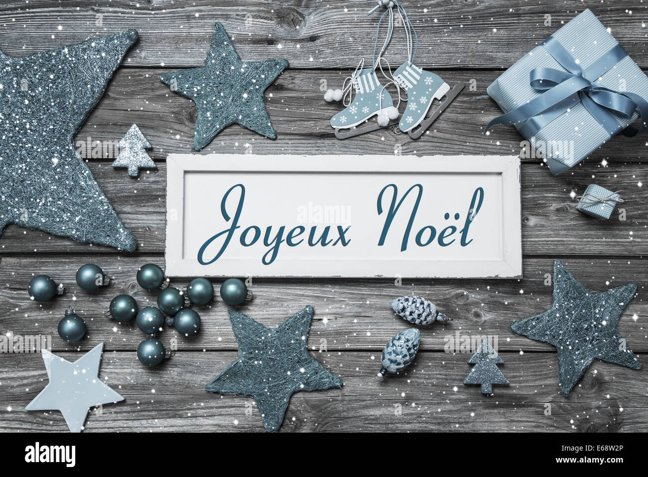 Merry Christmas card in shabby chic style in blue and white with french text on wooden board. Stock Photo