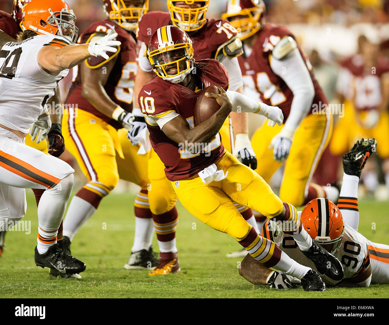 Landover, MD., US. 18th Aug, 2014. Washington Redskins quarterback Robert Griffin III (10) scrambles away from the tackle of Cleveland Browns defensive end Billy Winn (90) during the first half of their NFL preseason game at FedEx Field in Landover, MD Monday, August 18, 2014. Credit:  Harry Walker/Alamy Live News Stock Photo