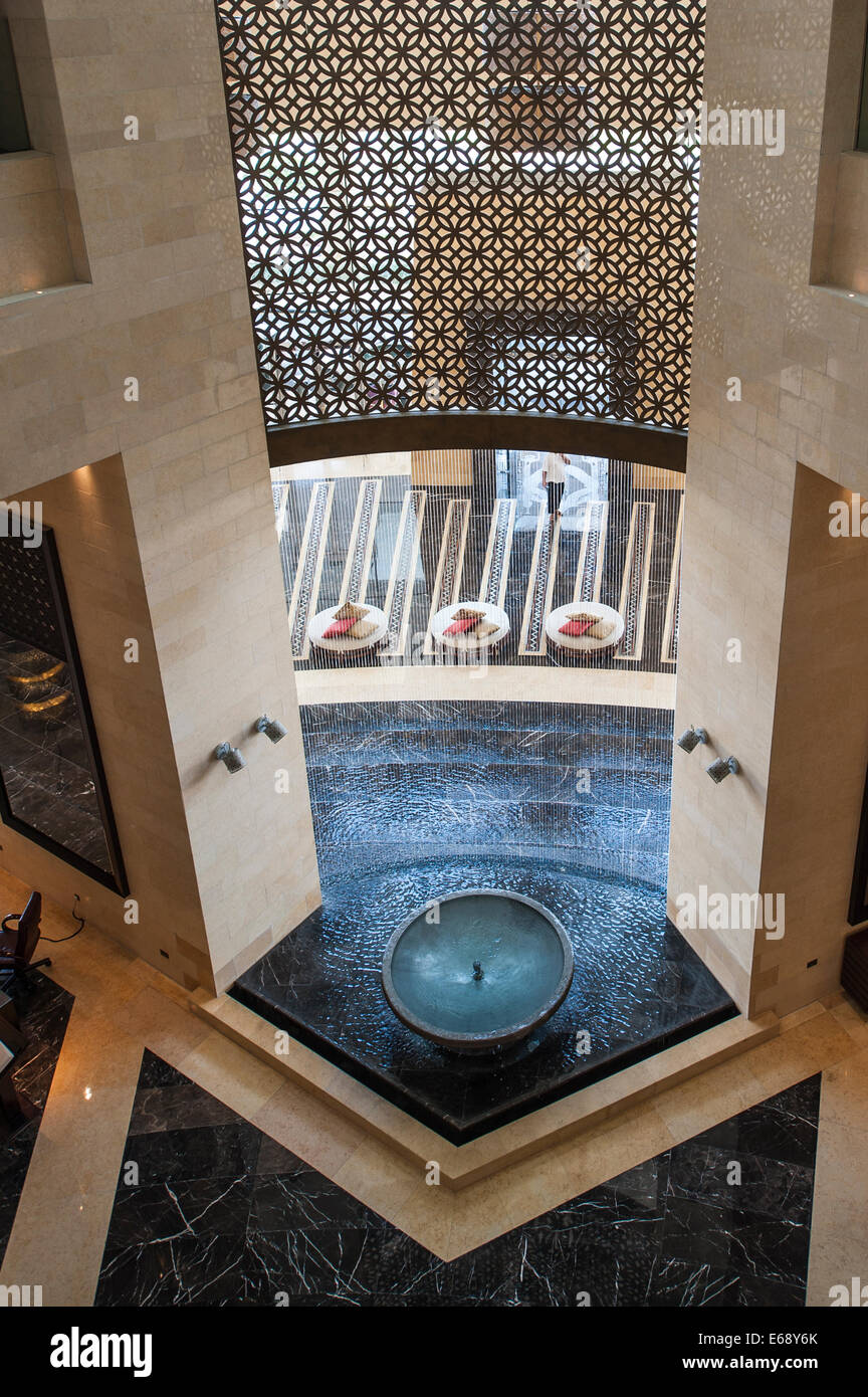 Entrance lobby lounge fountain seats of the Raffles Dubai Hotel Dubai, United Arab Emirates UAE. Stock Photo