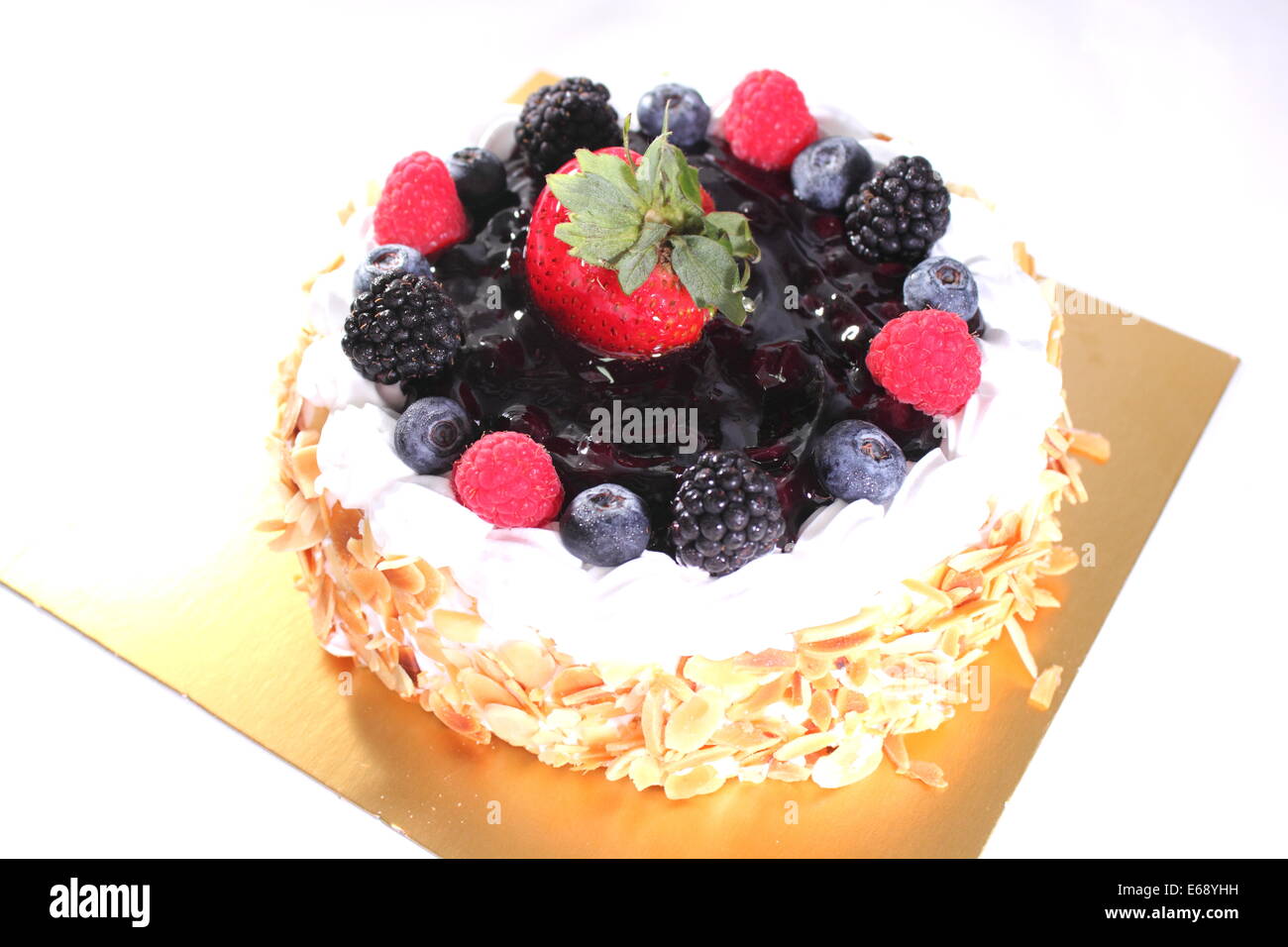 A piece of blueberry cheese cake on a tiny plate, the topping is strawberry. Stock Photo