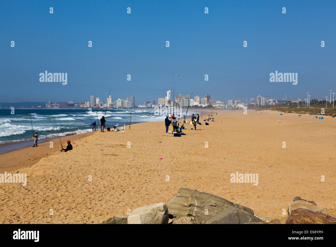 Durban South Africa. Fishermen on the beach with the iconic Moses Mabhida stadium and city of Durban South Africa in the background. Stock Photo