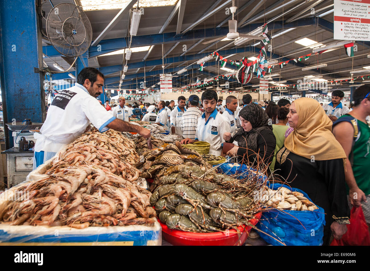 Fisherman with fish crab lobster shrimp in Deira fish market souk