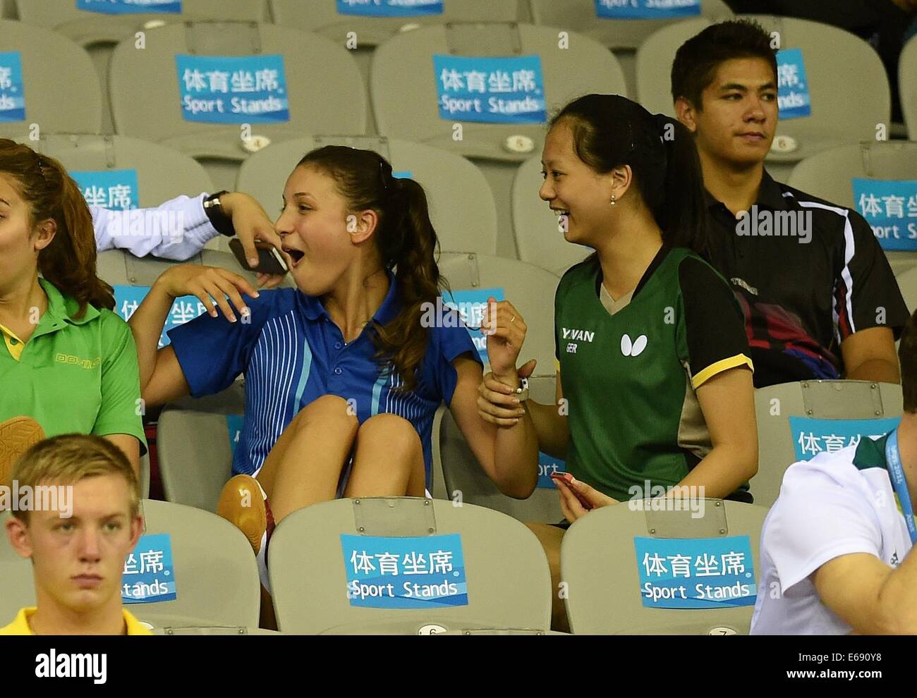 Nanjing, China's Jiangsu Province. 18th Aug, 2014. Audrey Zarif (3rd, R) of France communicates with Wan Yuan of Germany(2nd, R) in the grandstand at the Nanjing 2014 Youth Olympic Games in Nanjing, capital of east China's Jiangsu Province, on August 18, 2014. Credit:  Huang Xiaobang/Xinhua/Alamy Live News Stock Photo