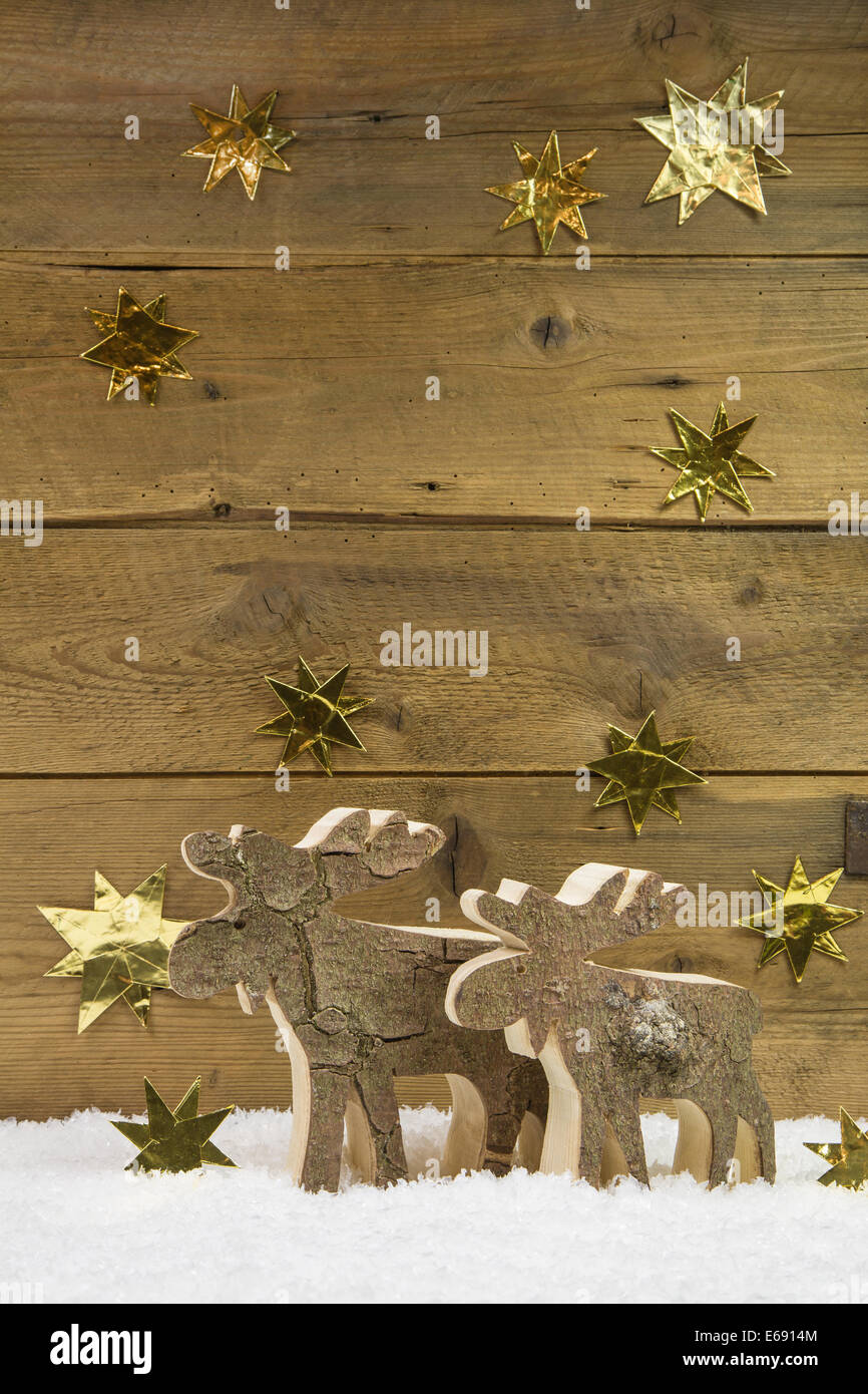 Two wooden elks on wooden christmas background. Vertikal size. Stock Photo