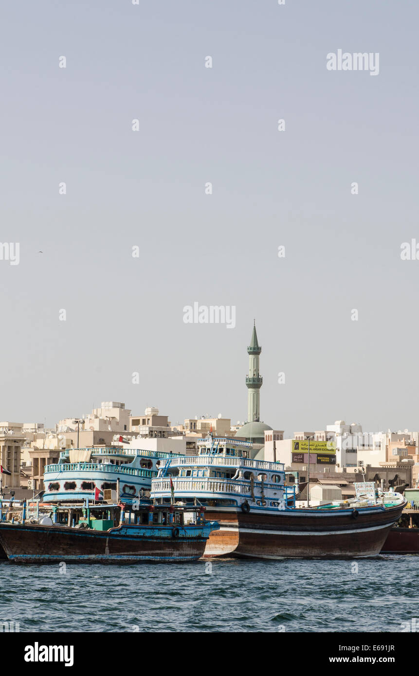 The minaret arab mosque towers over dhows boats at dock Bur Dubai ...