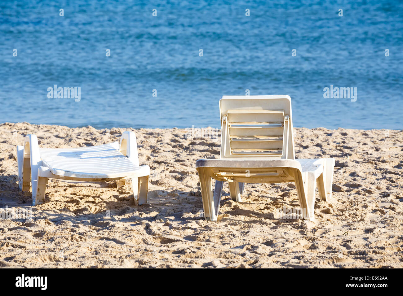 two old sun lounger on tunisian beach, no people, tranquil scene Stock Photo