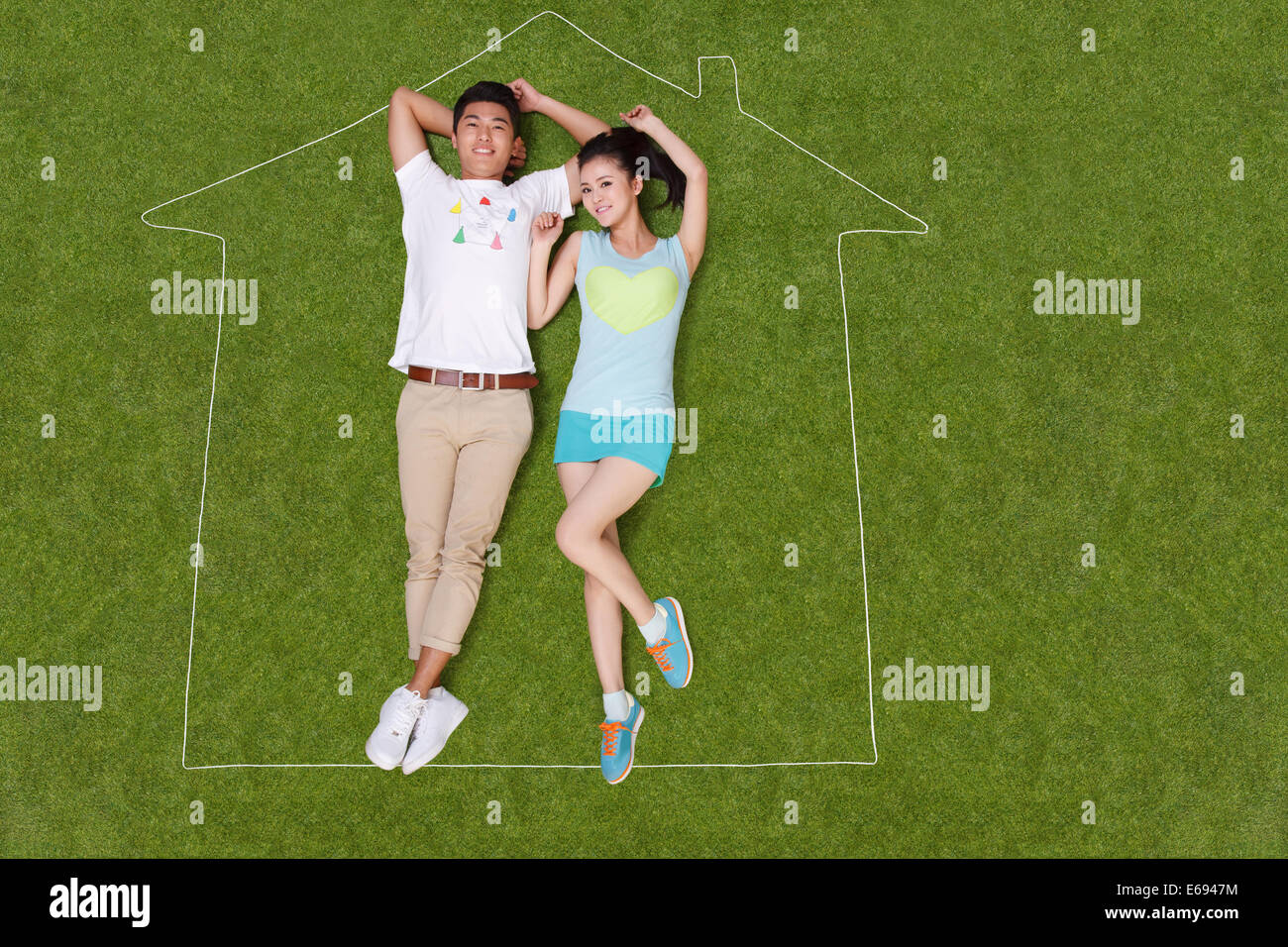 Young couple lying on grass in an artificial house Stock Photo - Alamy