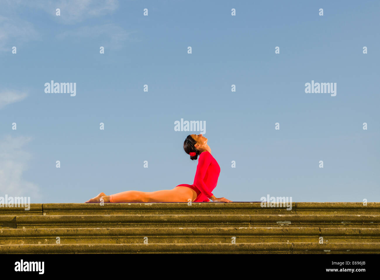 Young woman practising Hatha yoga, outdoors, showing the pose ...
