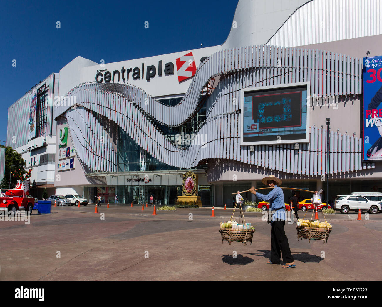 Market vendor carrying a yoke, in front of the Central Plaza Shopping Centre, Udon Thani, Isan, Thailand Stock Photo
