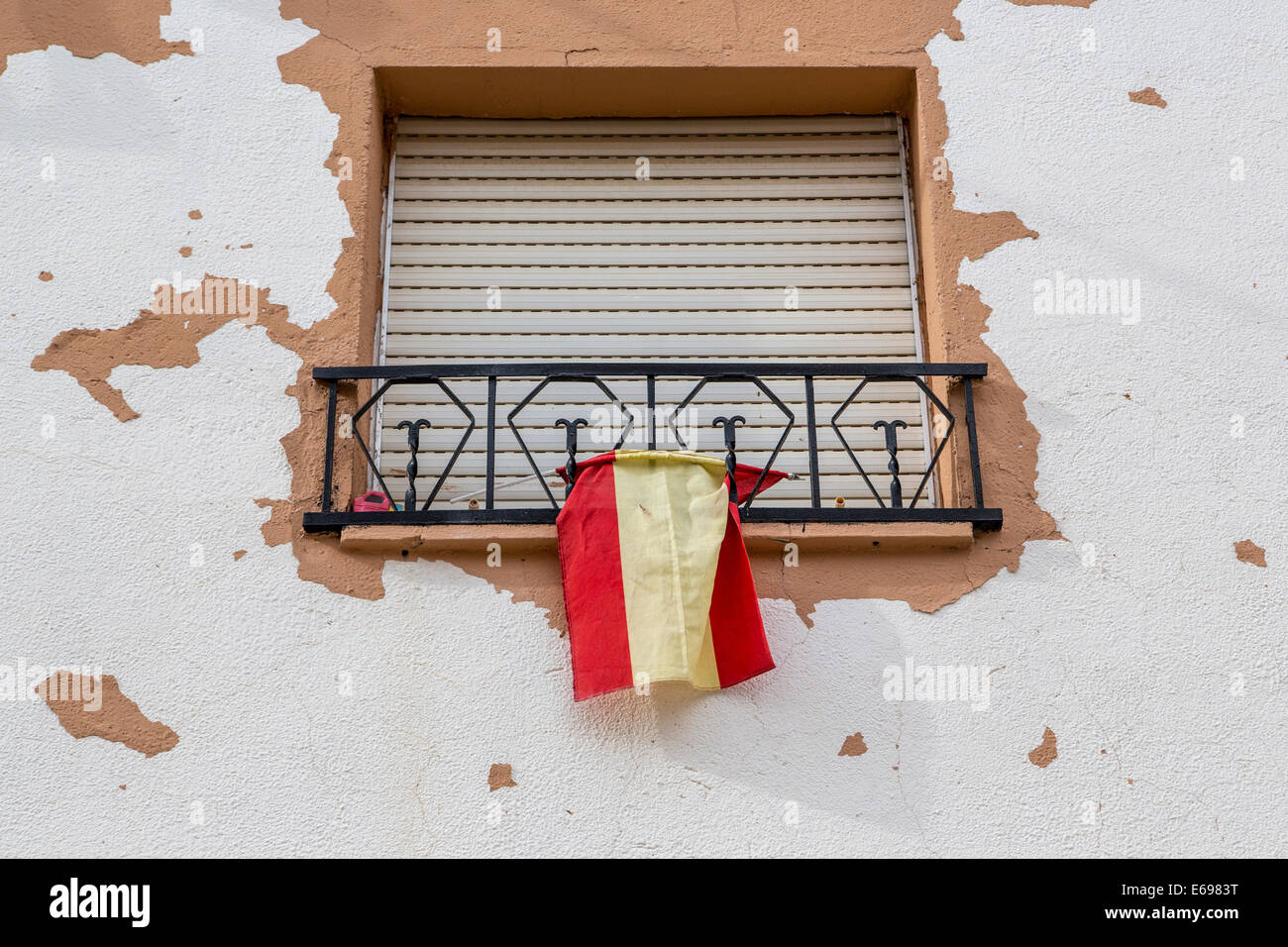 Window with closed blinds and Spanish flag, Humanes, Province of Guadalajara, Spain Stock Photo