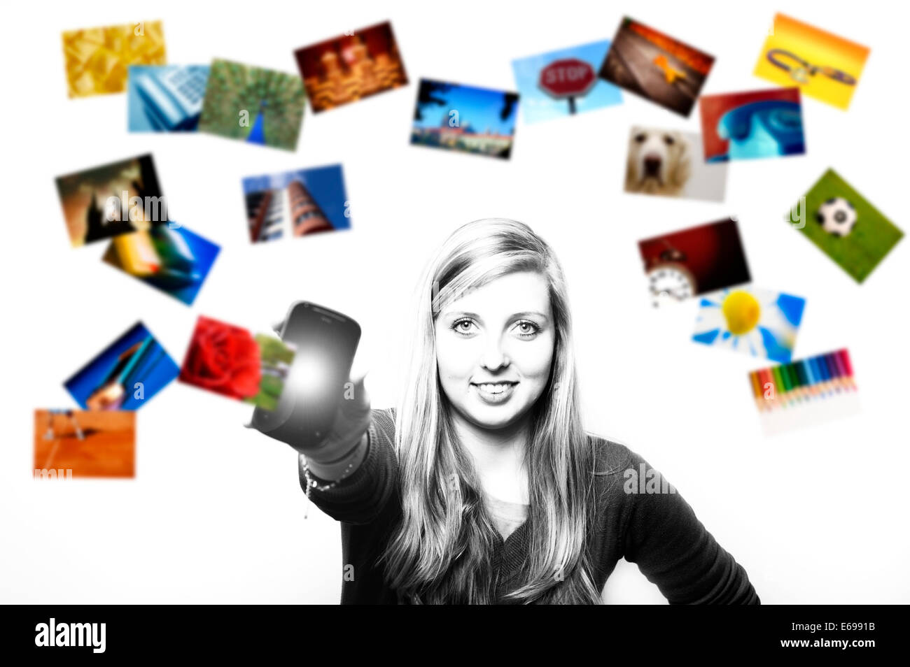 girl showing her smartphone with photos flowing around Stock Photo